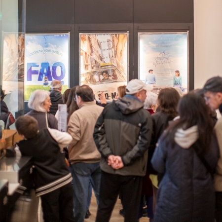 Fila di persone davanti i poster della rassegna cinematografica di film coreani